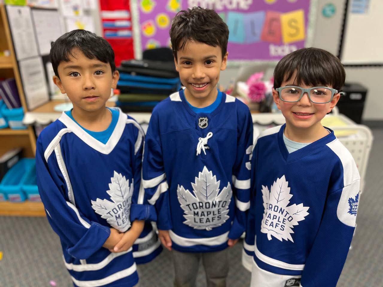 Three boys in Toronto Maple Leafs jerseys on spirit day