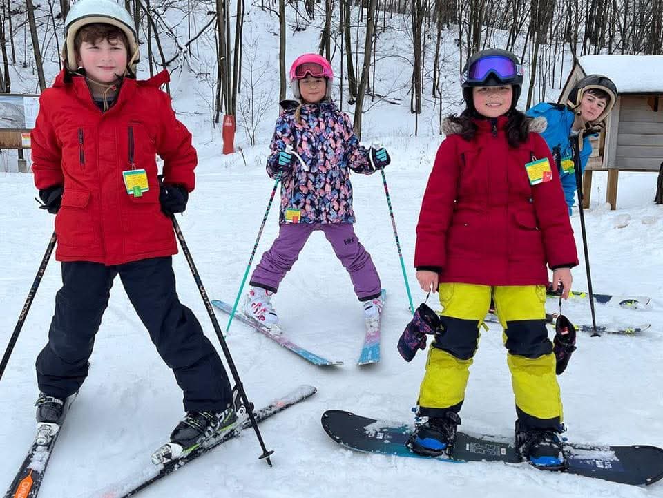 APA students skiing in colorful winter gear on snowy slopes